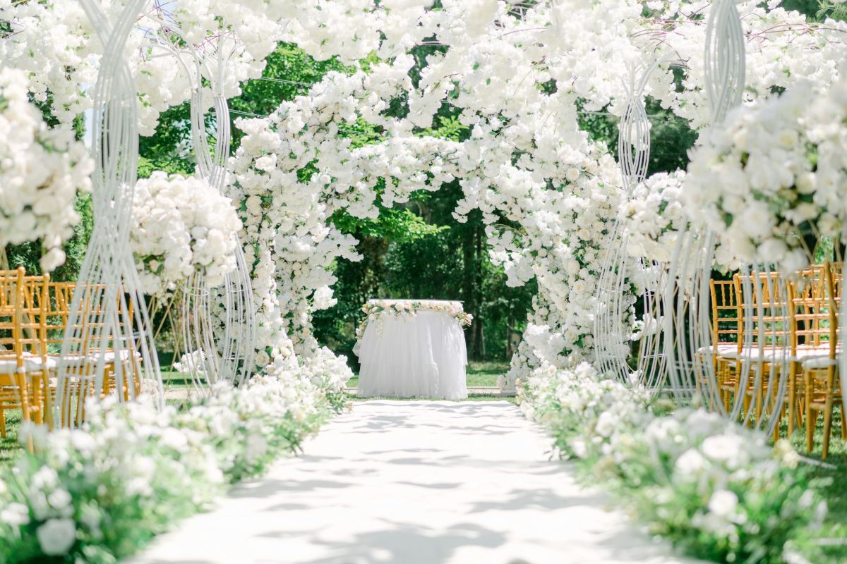 White floral wedding ceremony aisle with gold chiavari chairs